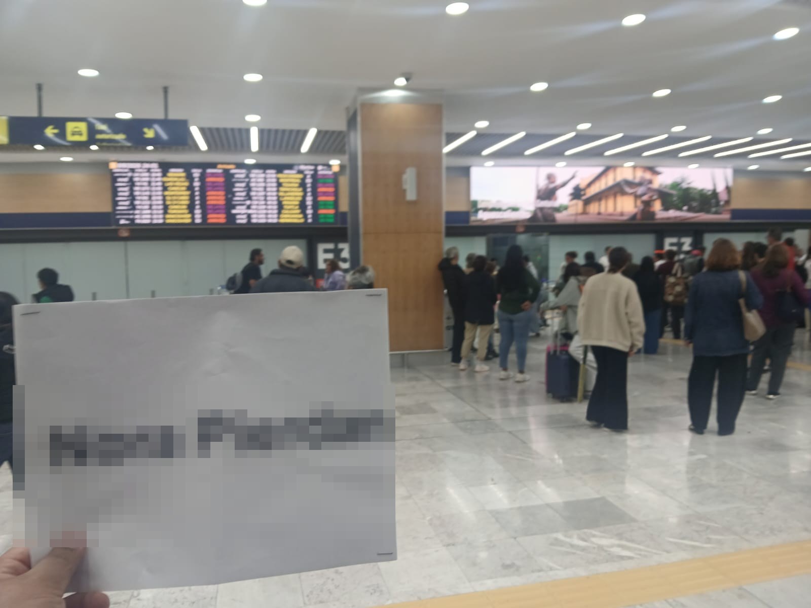 Recepción personalizada con cartel y datos protegidos en un aeropuerto